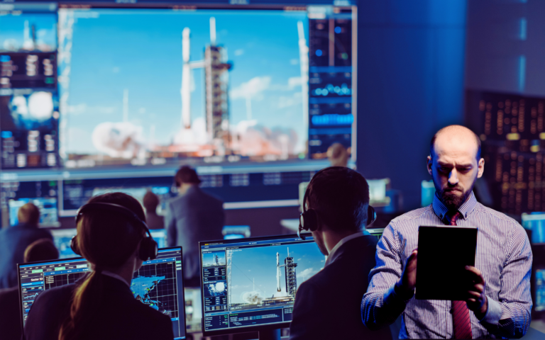 Team of engineers and IT professionals monitoring rocket launch systems in a control room, symbolizing the complexity and phases of the software development life cycle in aerospace and defense technologies.
